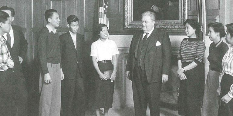 Herman B Wells speaks with a group of international students.